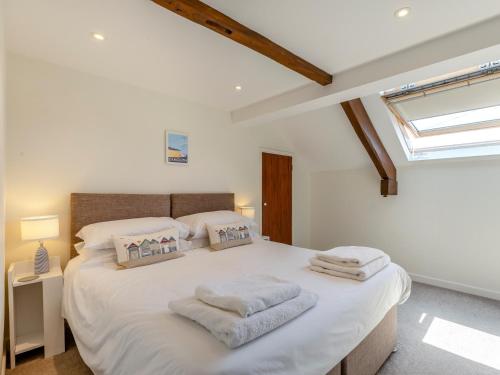 sypialnia z dużym białym łóżkiem z ręcznikami w obiekcie 3 bed property in Exeter 82586 w mieście Clyst Saint Mary