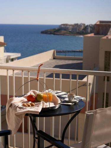 a table with a plate of food on a balcony at On The Port: Studio in Rafina