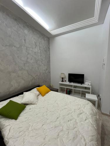 een slaapkamer met een wit bed met groene en gele kussens bij Barbi’s House in Napels