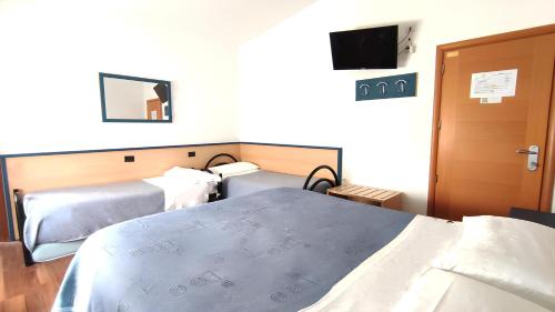 a hotel room with two beds and a television at Birilli B&B in Civitanova Marche