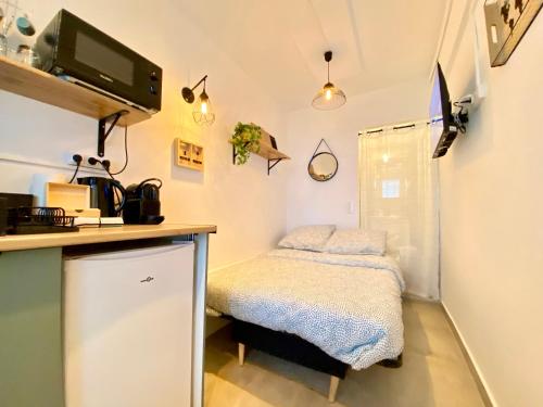 - une petite cuisine avec un petit lit dans une chambre dans l'établissement Mini-Studio Le Cormoran By SCLS Locations, à Cannes