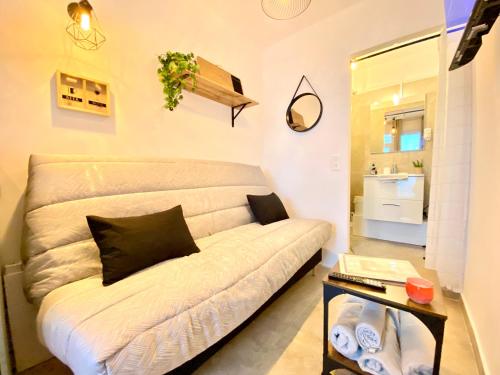 - un canapé blanc dans une petite chambre avec une table dans l'établissement Mini-Studio Le Cormoran By SCLS Locations, à Cannes