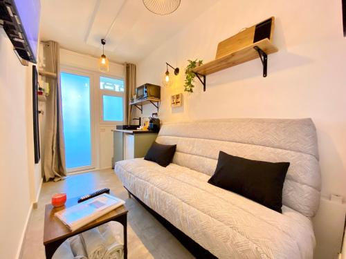 un salon avec un canapé et une table dans l'établissement Mini-Studio Le Cormoran By SCLS Locations, à Cannes