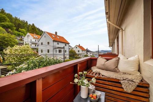 a balcony with a bench and pillows on it at Flott sentral 3 roms leilighet in Bergen