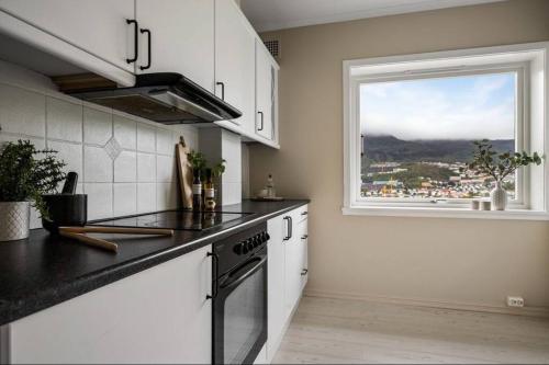 a kitchen with a stove and a window with a view at Flott sentral 3 roms leilighet in Bergen
