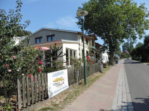 a house on a street with a fence and a sign at Pension Lemke in Polchow