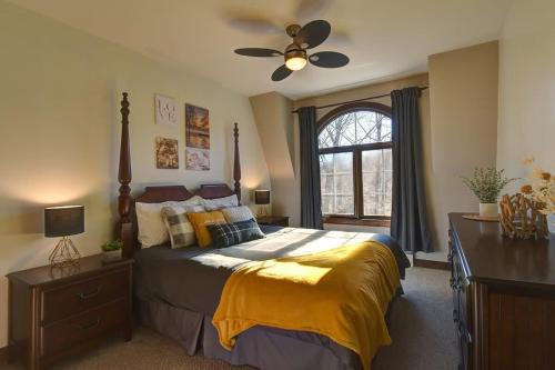 a bedroom with a bed and a ceiling fan at Huge condo in front of Tremblant ski resort in Mont-Tremblant