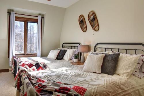 a bedroom with two beds and a window at Huge condo in front of Tremblant ski resort in Mont-Tremblant