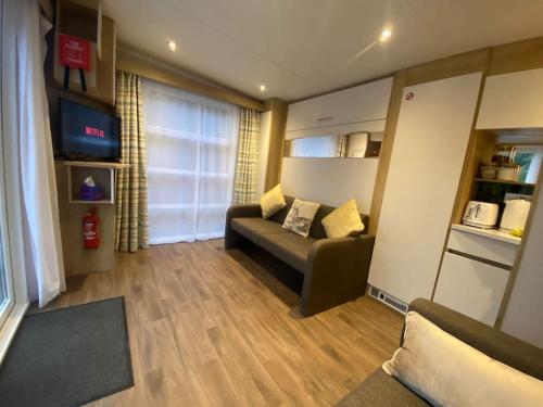 a living room with a couch and a television at Neptunes Pod in Fort William