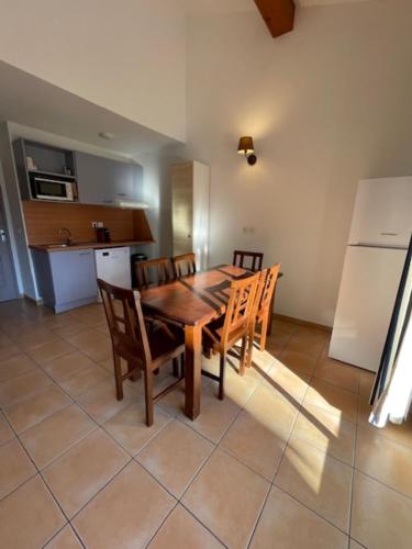 une cuisine et une salle à manger avec une table et des chaises en bois dans l'établissement Carro, proche de la mer, appartement 2 chambres, à Martigues
