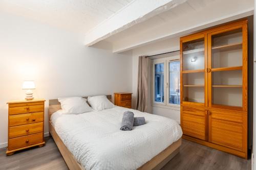 - une chambre avec un grand lit blanc et une armoire en bois dans l'établissement Central, 2 chambres, charmant., à Marseille