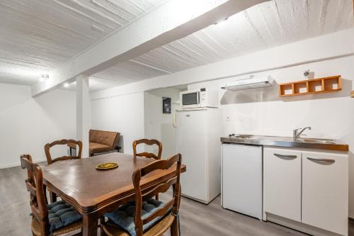 une cuisine et une salle à manger avec une table en bois dans l'établissement Central, 2 chambres, charmant., à Marseille