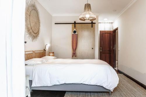 a bedroom with two beds and a pendant light at Private pool Sunset Terrace Apartment in Ericeira