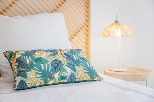 - un lit avec un oreiller et une lampe dans l'établissement Picasso & Terrasse - 2 Chambres, à Brive-la-Gaillarde