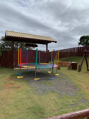 a playground with colorful swings and a gazebo at Chácara Recanto Quero-Quero in Tatuí