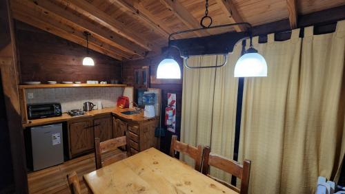 a kitchen with a wooden table and a dining room at Estancia Laguna Vitel in Chascomús