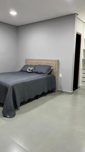 馬留坎普斯的住宿－Apartamento 3 quartos - completo - próximo ao Inhotim，一间卧室配有一张带灰色床罩的床