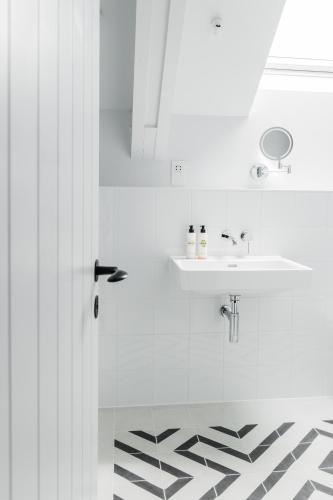 a white bathroom with a sink and a mirror at The Millbrook Inn in Kingsbridge