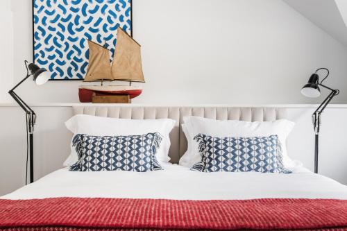 a bedroom with a bed with blue and white pillows at The Millbrook Inn in Kingsbridge