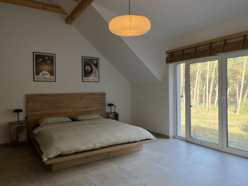 een slaapkamer met een bed en een glazen schuifdeur bij Willa Powaga in Łeba