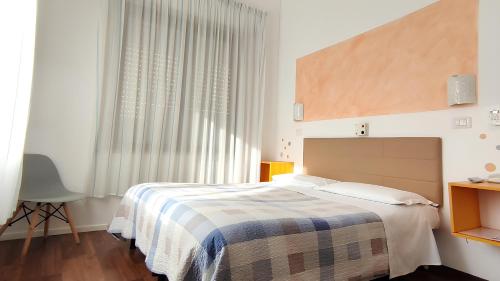 a bedroom with a bed and a large window at Birilli B&B in Civitanova Marche