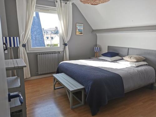 - une chambre avec un grand lit et une fenêtre dans l'établissement Plage du Pont - Chambres d'Hôtes, à Saint-Malo