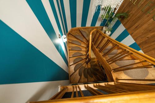 a wooden spiral staircase in a room with a striped wall at Elegant Apartments in Poznań