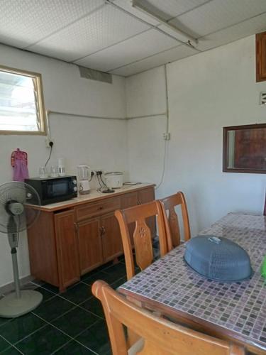 a dining room with a table and a microwave at Mariah Homestay @ Station 18 in Ipoh