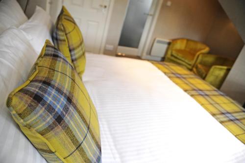 a bedroom with a bed with two pillows on it at The Dowans Hotel of Speyside in Aberlour