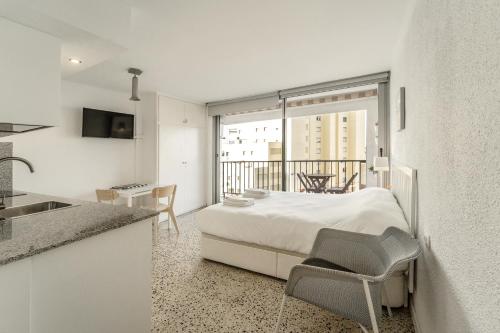 a bedroom with a bed and a kitchen with a balcony at WELCS ESTUDIO 120 EMP cerca del mar in Empuriabrava