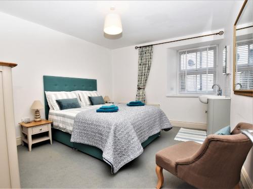 a bedroom with a bed and a chair at 4 Bed in Ilfracombe 45121 in Ilfracombe