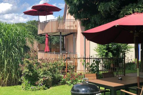 eine Terrasse mit Tisch und Sonnenschirmen in einem Hof in der Unterkunft Annehill Ferienwohnungen am Wittenborn in Hannoversch Münden