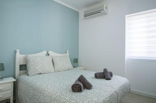 a bedroom with a bed with towels on it at Altura Beach & Village Escape by Lisbeyond in Altura