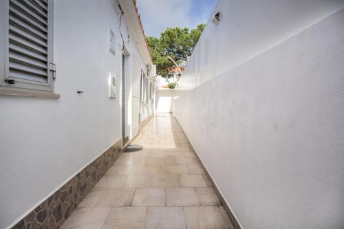 a hallway with a white wall and a tile floor at Altura Beach & Village Escape by Lisbeyond in Altura