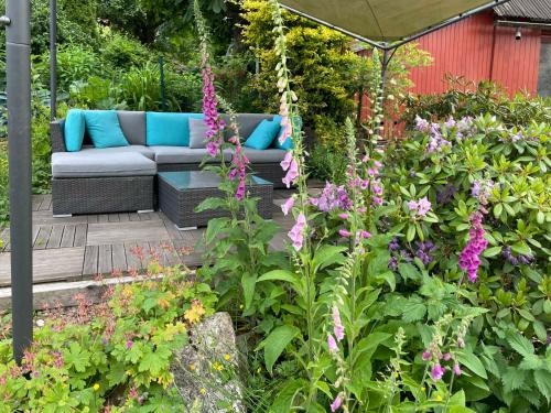 - un jardin avec un canapé et quelques fleurs dans l'établissement Gästehaus Bonaforth, à Hann. Münden