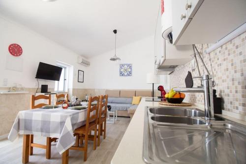 a kitchen and living room with a table and chairs at Altura Beach & Village Escape by Lisbeyond in Altura