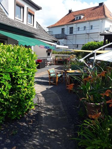 Un patio con mesas y sillas frente a un edificio. en Haus am Vogelsang, en Hannoversch Münden