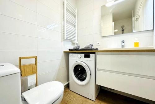 une salle de bain blanche avec une machine à laver à l'intérieur dans l'établissement Le Temps d'une Pause - 350m de la grande plage, à Les Sables-dʼOlonne