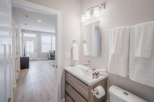 a white bathroom with a sink and a toilet at New Construction New Furnishings Luxury Unit in Evansville