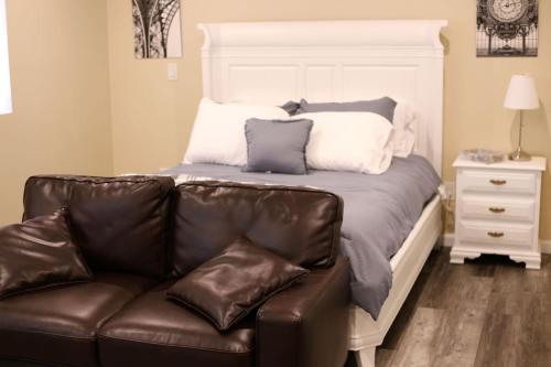um sofá num quarto com uma cama com almofadas em Enchanting suite nestled in quaint Santa Clarita em Santa Clarita