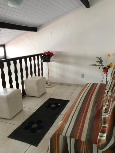 a living room with two chairs and a rug at Casa em condomínio com churrasqueira in Cabo Frio