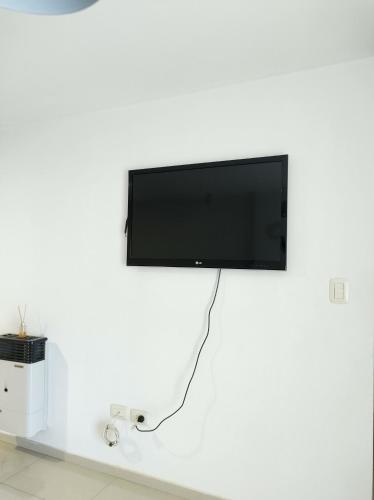 a flat screen tv hanging on a white wall at Departamento Skala in Cordoba