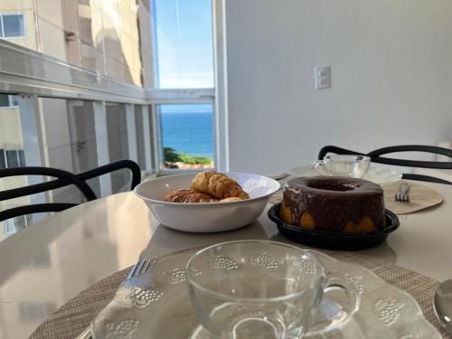 a table with a bowl of food and a bowl of bread at Praia & Pé na areia Itaparica in Vila Velha