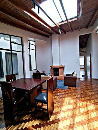 um quarto amplo com uma mesa de madeira e cadeiras em Hermoso departamento en Ambato em Ambato