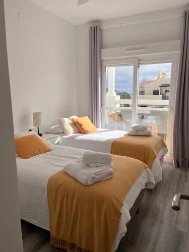 2 łóżka w sypialni z widokiem na balkon w obiekcie Atico Playa Granada Marina Golf w mieście Motril
