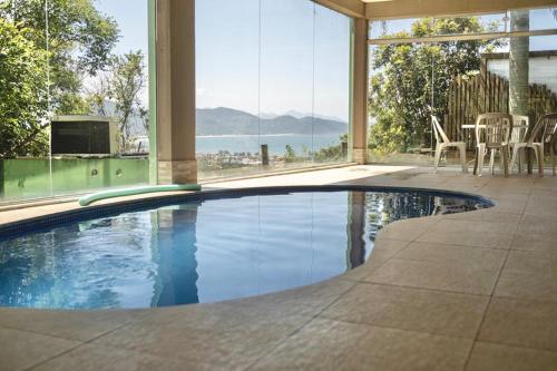 a swimming pool in a house with a view of the ocean at Silveira Eco Village Residence in Garopaba