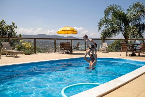 a man and a boy in a swimming pool at Silveira Eco Village Residence in Garopaba