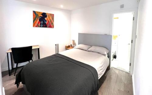 een slaapkamer met een bed, een bureau en een raam bij Modern Studio Apartment with Free Wifi in Hither Green