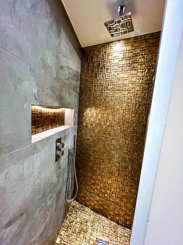 a bathroom with a shower with a tiled wall at Modern Studio Apartment with Free Wifi in Hither Green