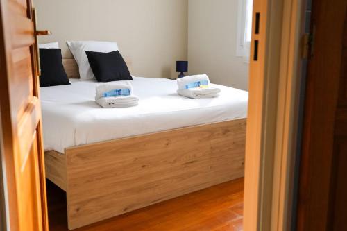 a bedroom with a bed with white sheets and pillows at La villa Fontaine in Moussy